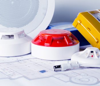 Fire security equipment and blueprint on a table. Good for security servise engeniering company site or advertising